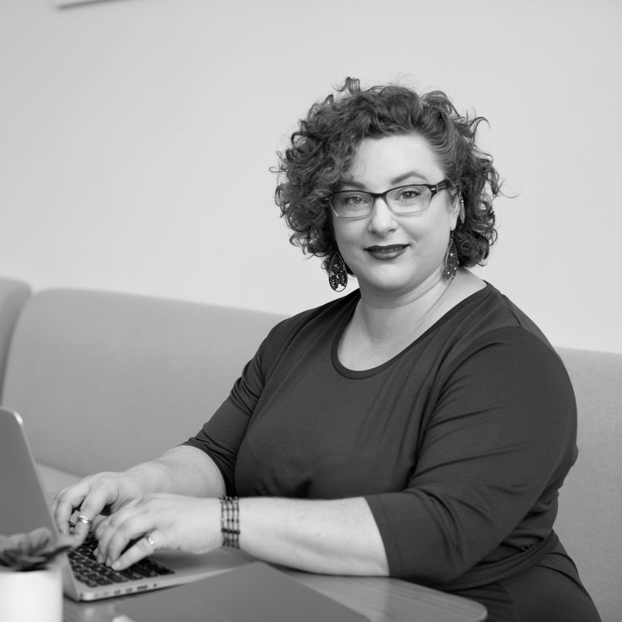 lady with glasses typing on laptop